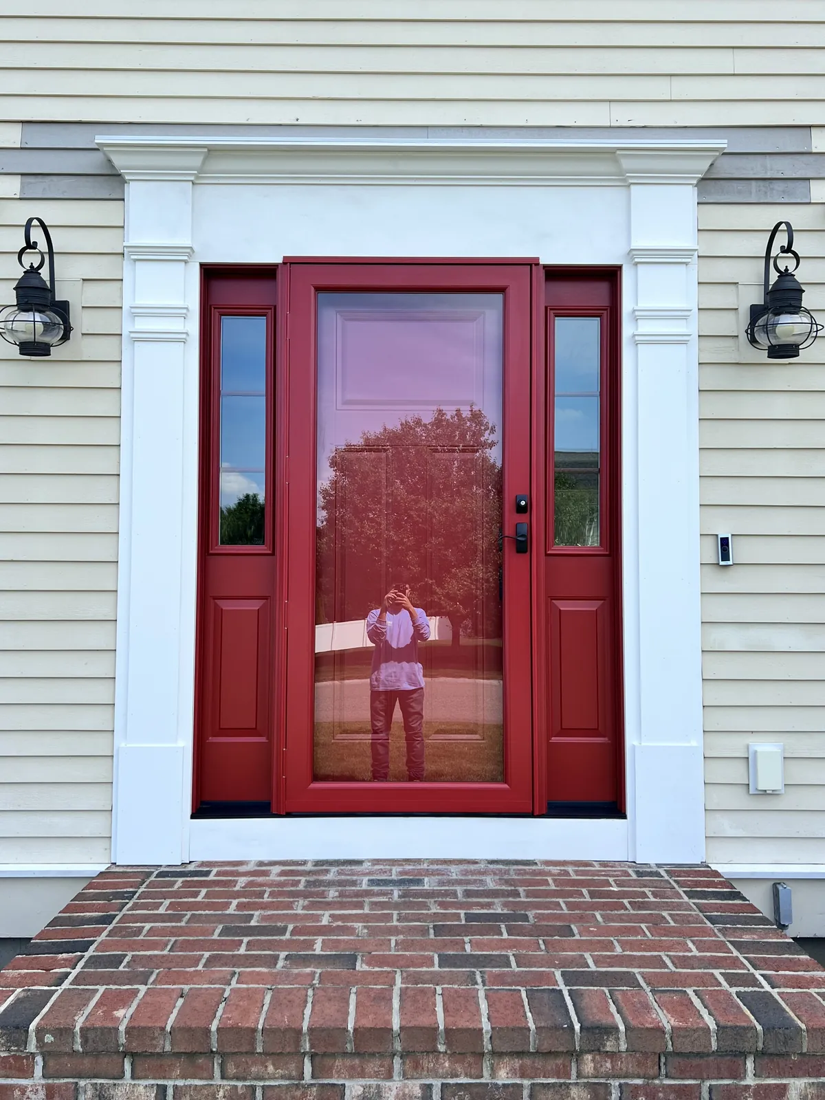 Deep red entry door with white surround on a brick step