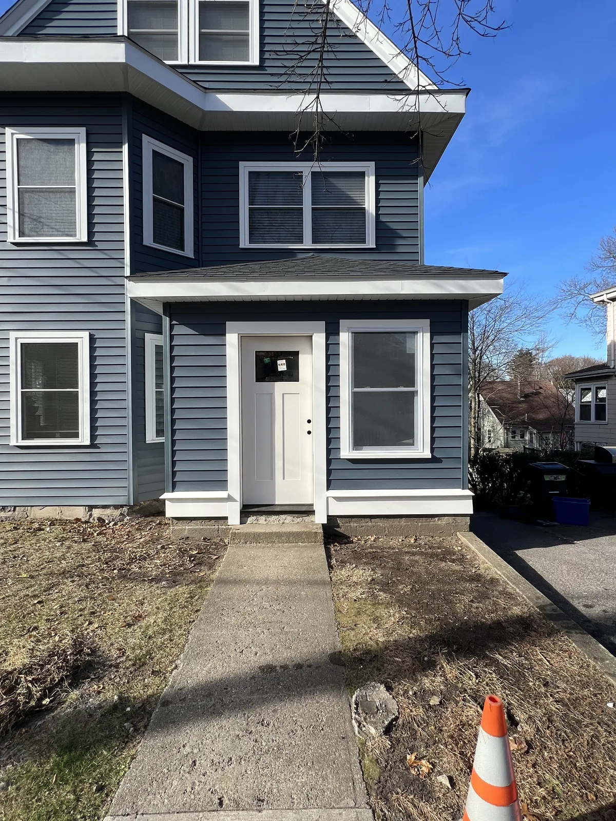 Two-story home finished in navy blue siding with white trim