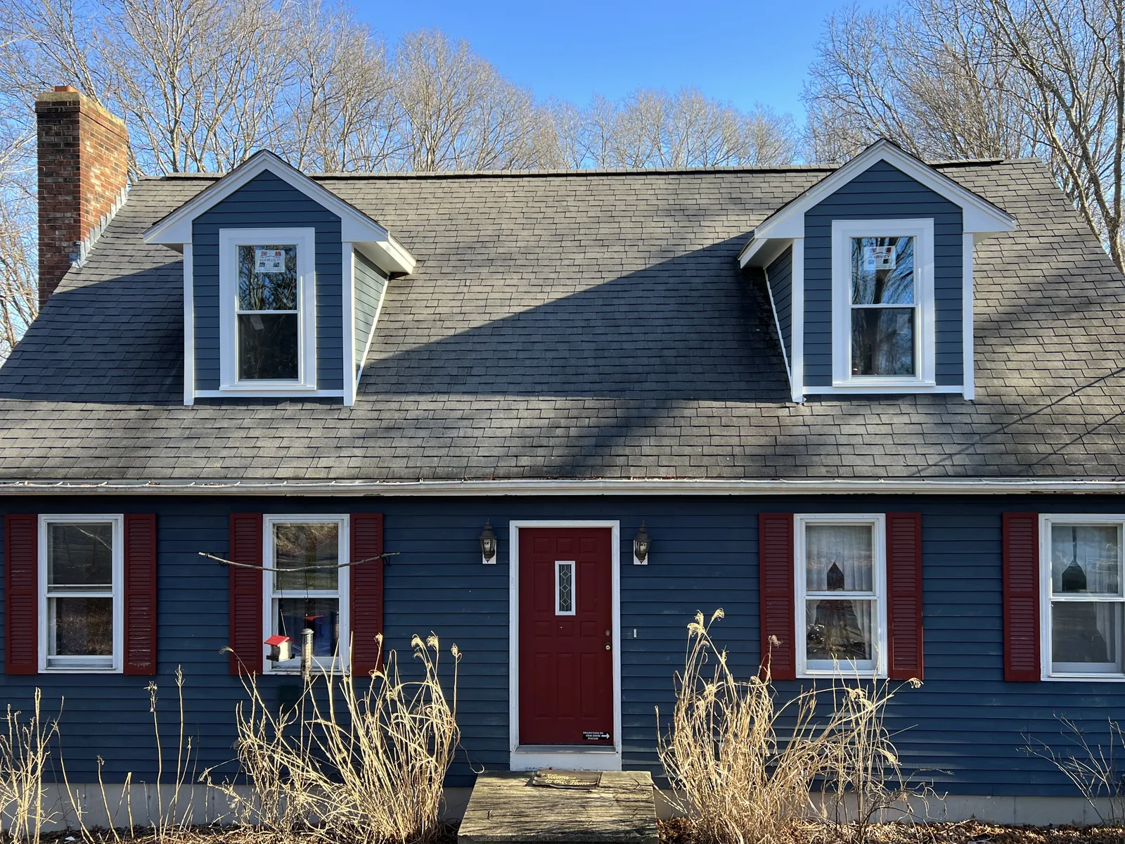 Cape home with blue siding, red door and white trim