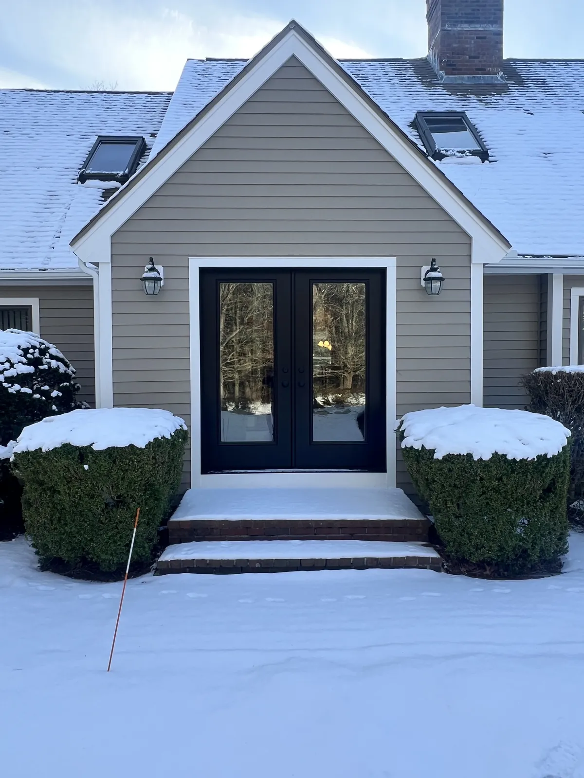 Gray home with new front entry doors and stone landing