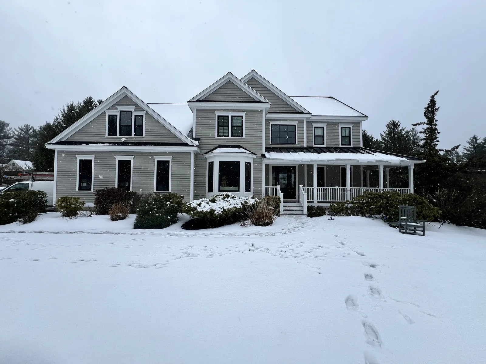 Colonial home under snow with replacement windows throughout