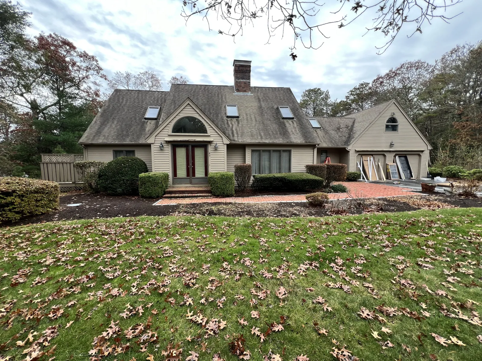 Shingle-style home with arched entry